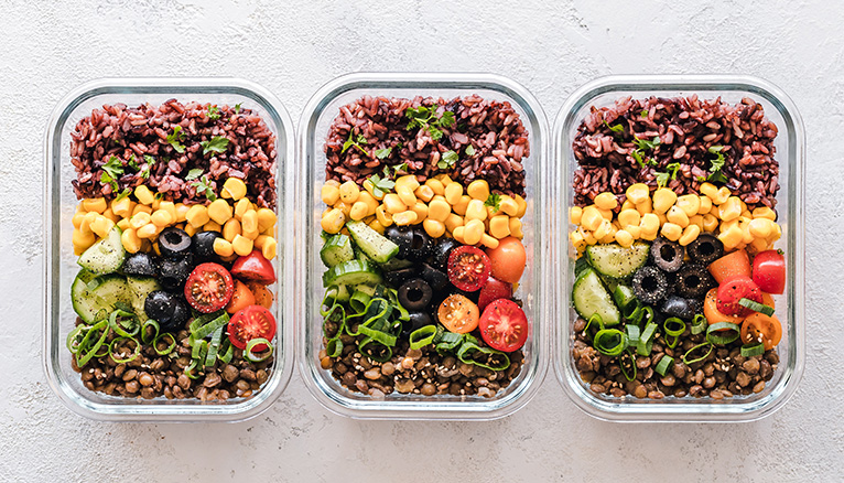 Three glass containers packed with colourful, healthy salads.