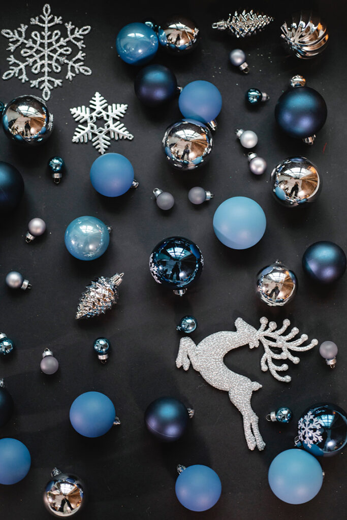 Blue, silver and bronze Christmas baubles, snowflakes and a glittery reindeer. 