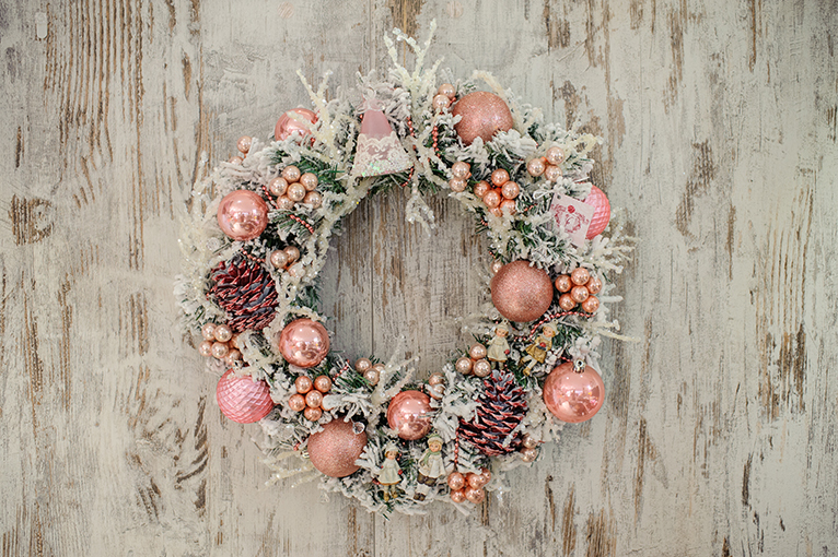 Holiday wreath with pink-pastel and peach coloured baubles. 
