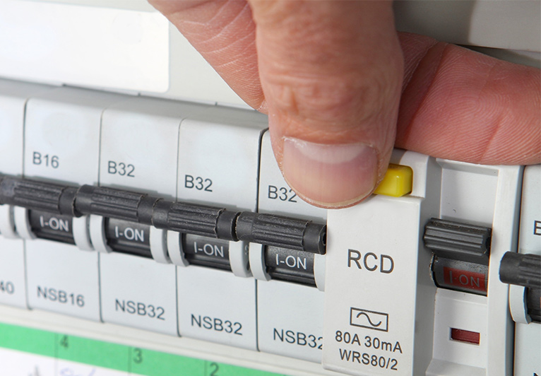 Electricians hand overing over RCD label on a fuse board.