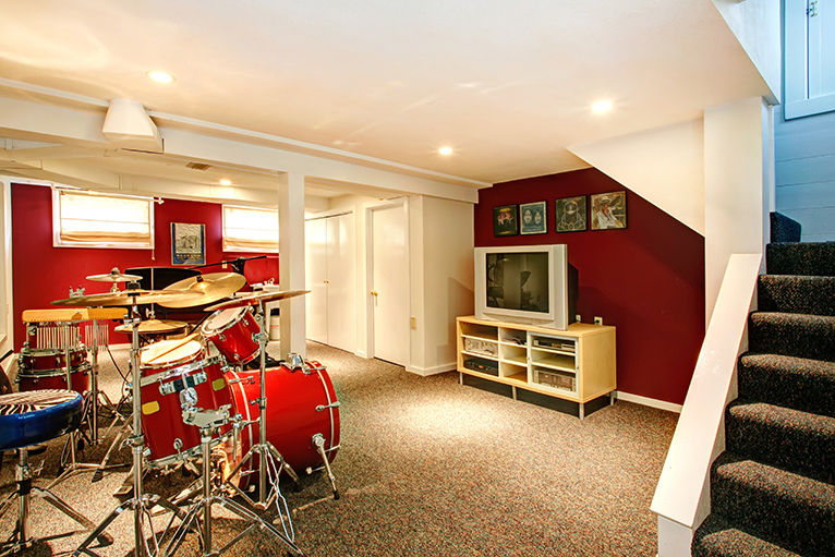 Basement hang out room with a drum kit and TV.