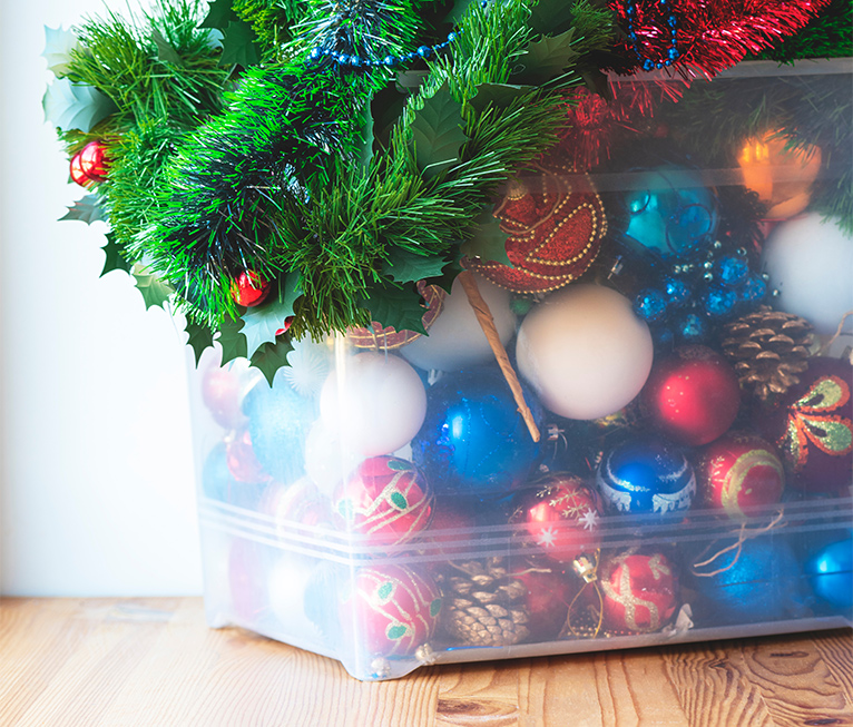 Clear plastic storage container filled with Christmas tree decorations. 