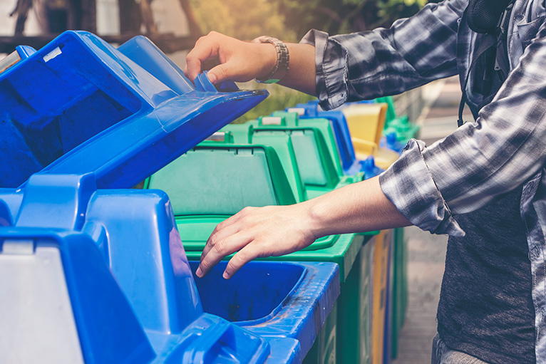 Man placing waste in recycling bin
