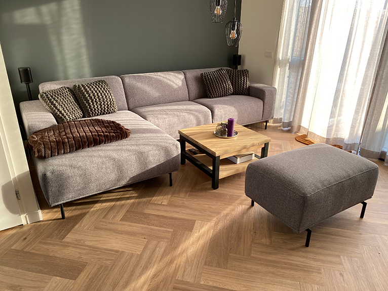 medium coloured herringbone floor in a living room with a taupe L-shaped sofa and coffee table