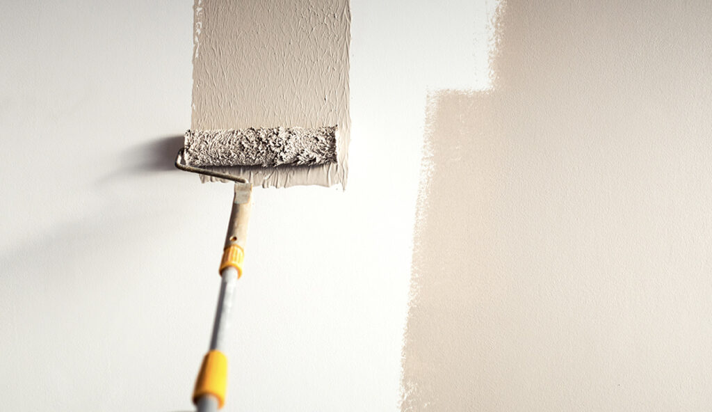 White wall being painted with pastel colour