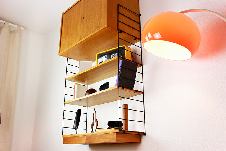 wall mounted mid century style modern open shelving with 70s style lamp next to it