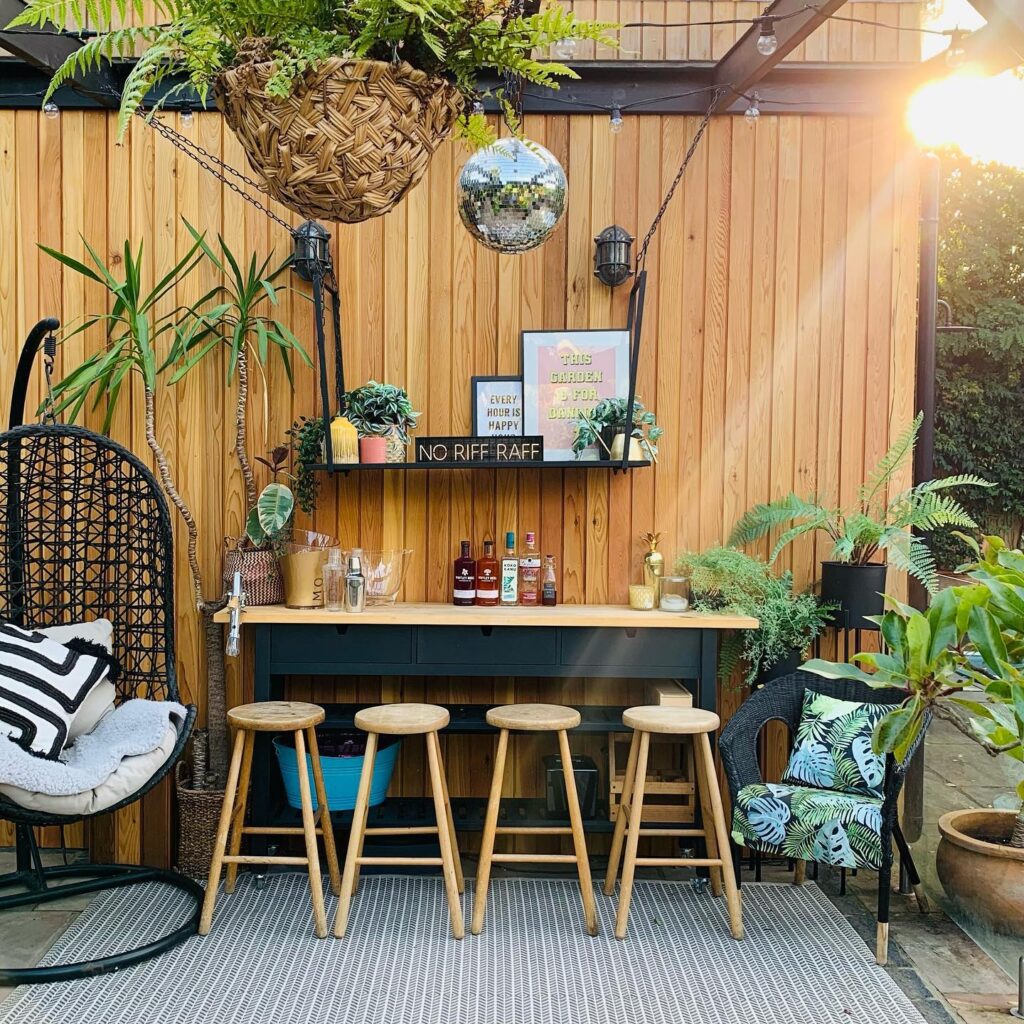 home bar in the garden with wooden stools and wall panelling