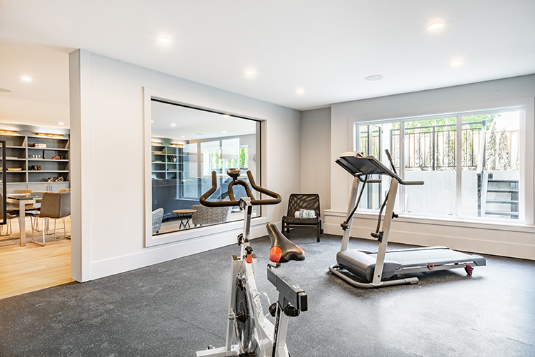 Modern home gym with large windows and mirror