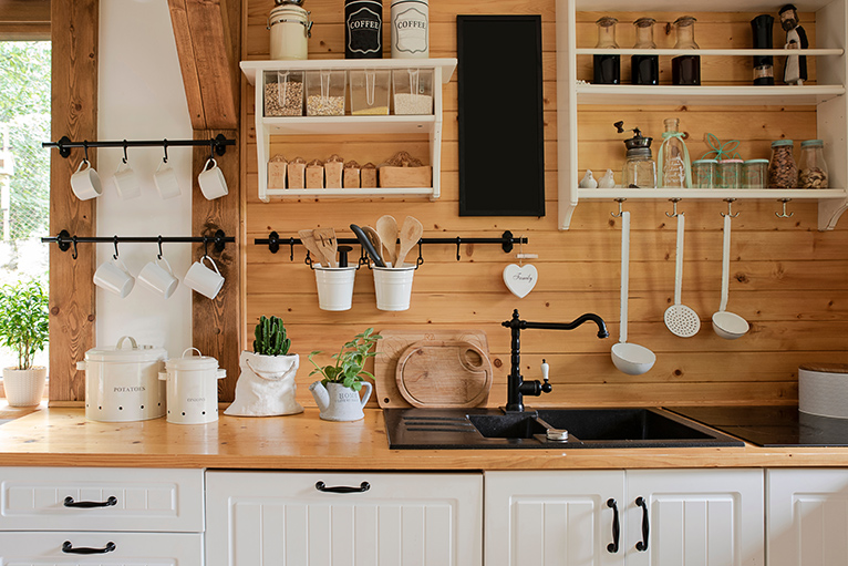 Cottagecore décor: rustic, white kitchen furniture with pine worktop and wall cladding