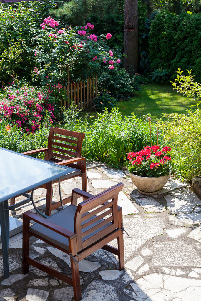 Outdoor seating area with summer garden in full bloom in the background