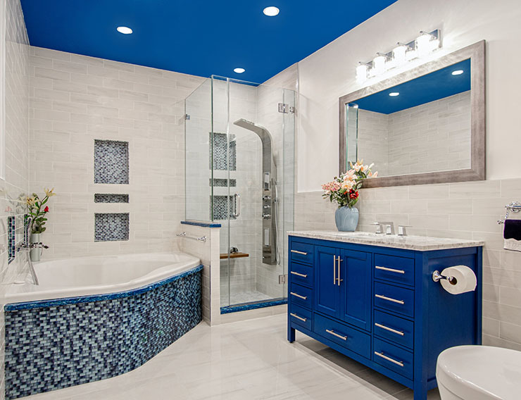Picture of a bathroom with blue cabinets and beige tiling.