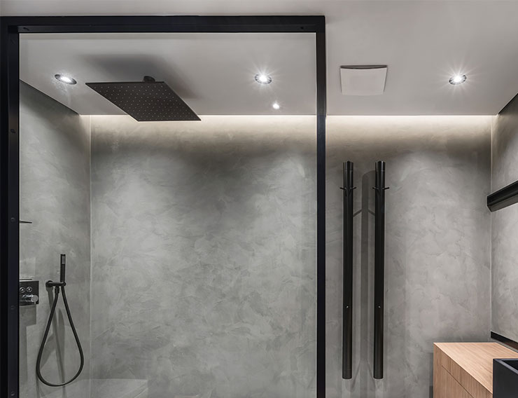 Bathroom in a modern style with gray tiled walls and waterfall shower