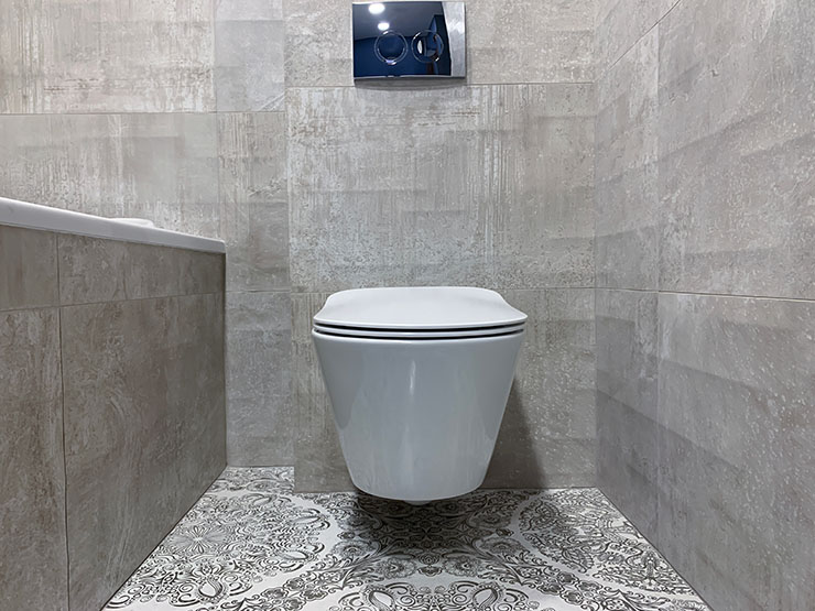 Photo of a wall hung toilet in a newly renovated, tiled bathroom.