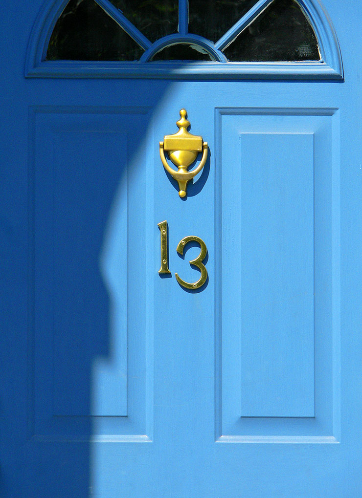 Blue door with brass knocker and the number 13.