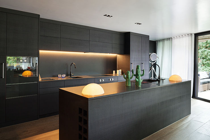 Image of a kitchen using black and dark colours and modern furniture