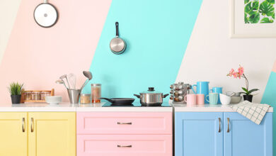Colourful kitchen with striped wallpaper and colourful cabinets