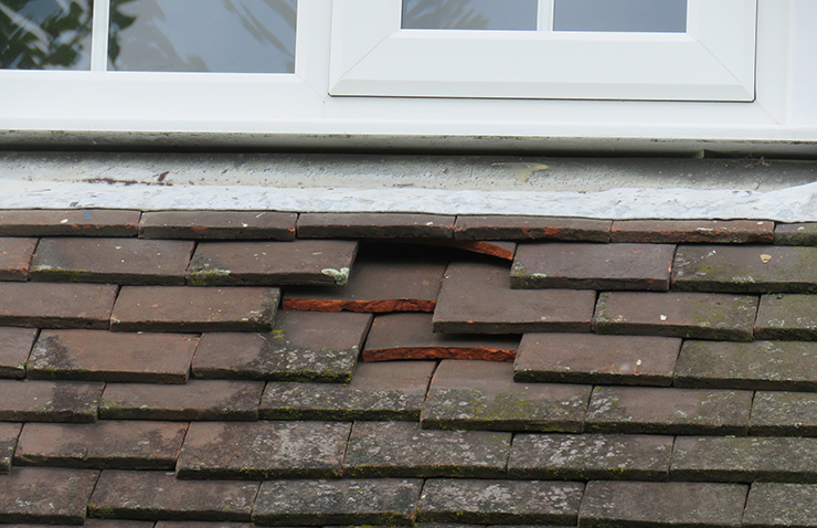 Picture of a damaged roof with loose tiles