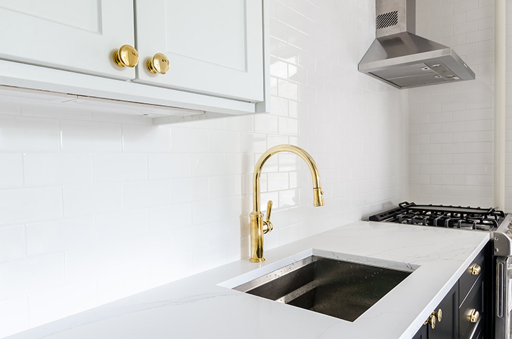 Picture of a kitchen sink with gold taps