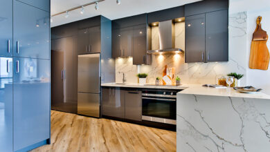 Picture of a kitchen with marble counters, grey cabinets and wooden floors