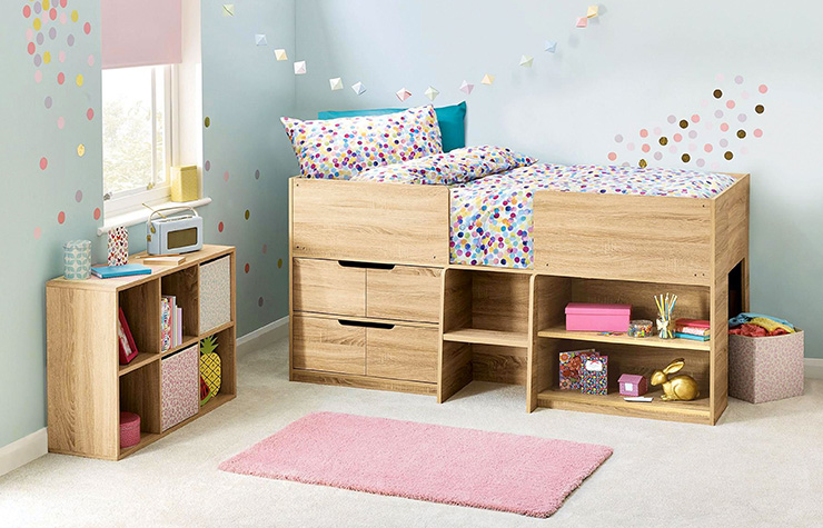 Child's bedroom interior with wooden raised bed. Walls are painted blue and there is a pink rug on the floor.