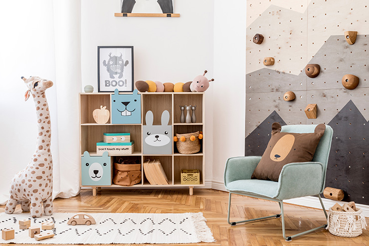 Scandinavian interior design of playroom with modern climbing wall for kids, design furnitures, mint armchair, soft toys, teddy bear and cute children's accessories. Mock up poster frame. 