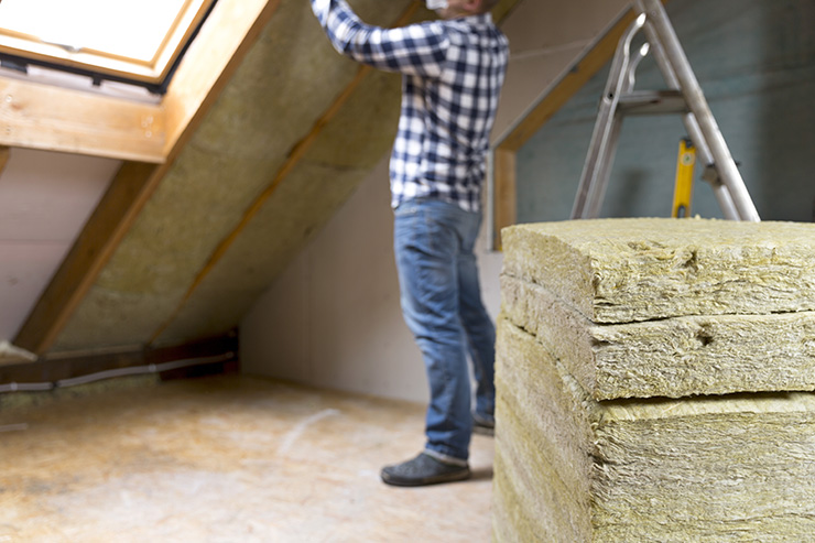 Picture of a person installing loft insulation in their home