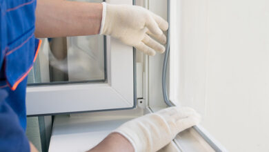 Picture of a tradesperson replacing a window wearing white plastic gloves