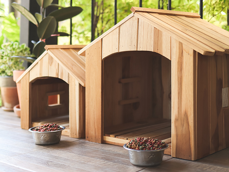 Picture of two wooden dog kennels with dog food bowls