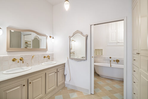 Picture of two mirrors in bathroom with chequered floor tiles