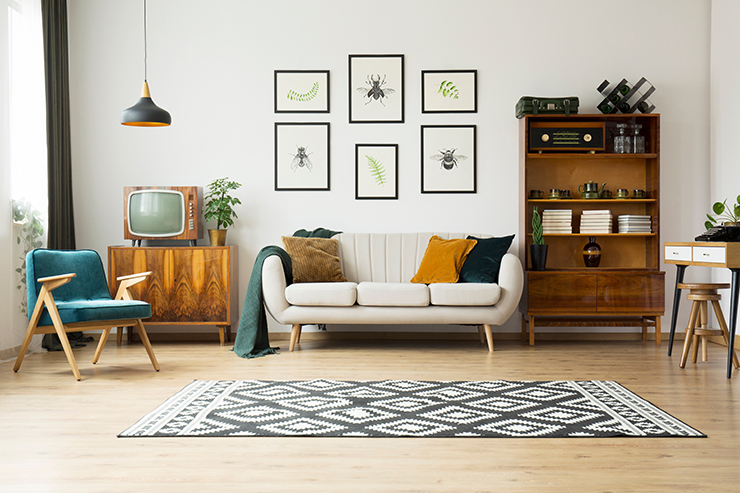 Picture of a living room with rug, prints, and wooden furniture in Scandinavian style