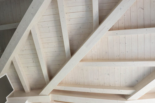 Picture of a wooden roof with wood beams painted white