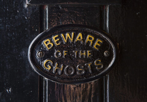 Picture of a sign on a door that says beware of the ghosts