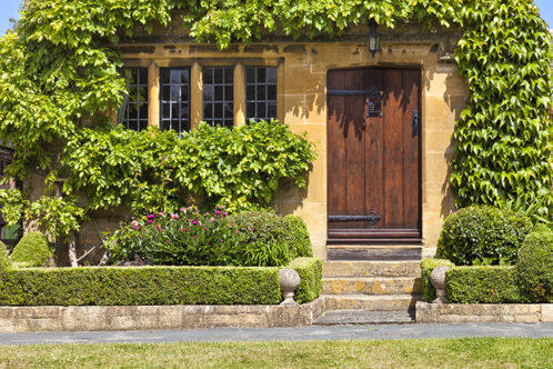Picture of a neatly curated front door and hedge