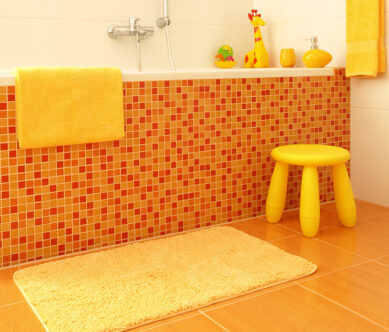 Picture of an orange bathroom with yellow and orange mosaic on bathtub