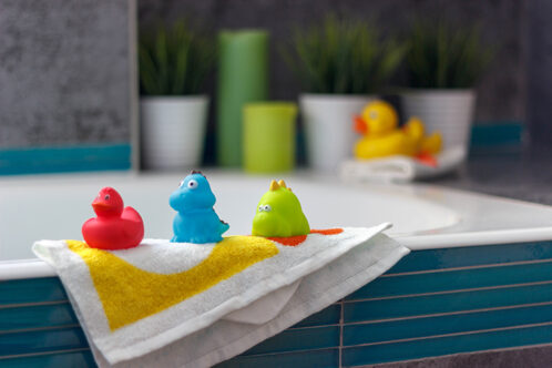 Picture of three coloured duckies on a bathtub in bathroom