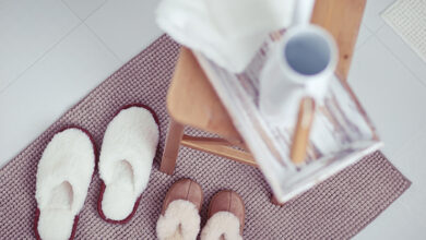 Picture of two sets of slippers adult and child on a mat beside a chair