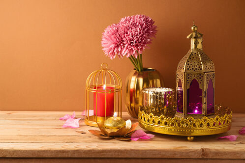 Picture of a vase of flowers, an golden tray with lit candle