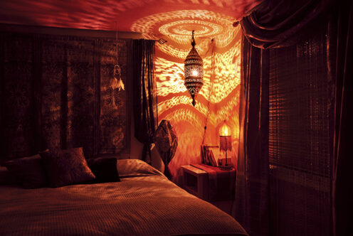 Picture of a bedroom with a colourful lamp reflecting light