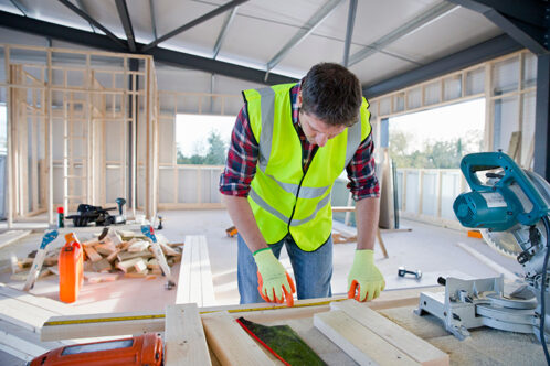 Picture of a man in a high vis jacket in a house being constructed