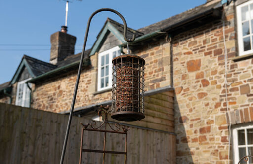 Picture of a home with a rusty birdfeeder in the garden