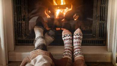Picture of two pairs of feet in festive socks by the fire