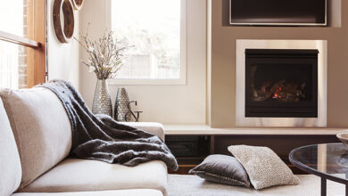 Picture of a living room with fireplace and blanket on sofa