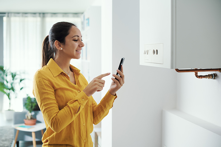 Picture of a woman on the phone programming her smart boiler