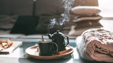 Picture of a mug and pot of tea on table in living room