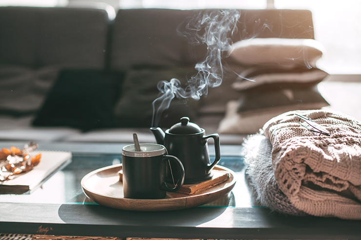 Picture of a mug and pot of tea on table in living room