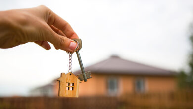 Picture of a house with hand holding keys in foreground