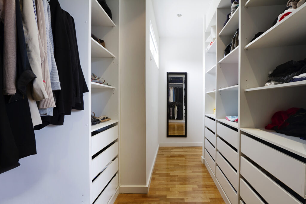 Picture of a walk in wardrobe in white with wooden floors