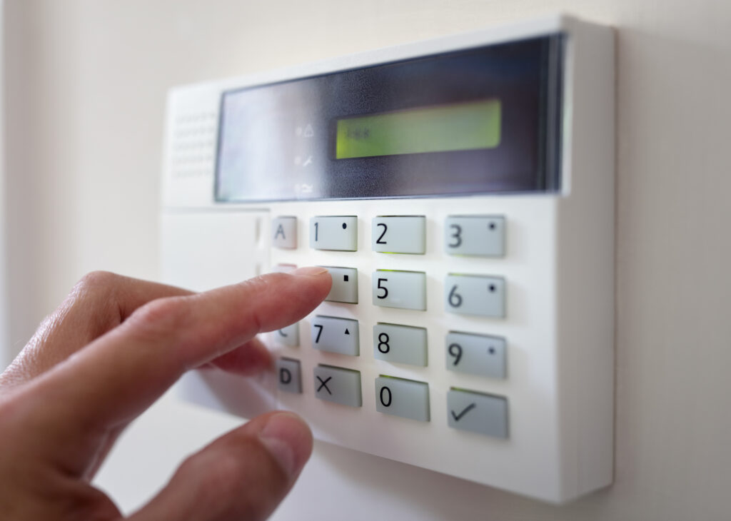 Picture of a hand pressing button on a burglar alarm keypad