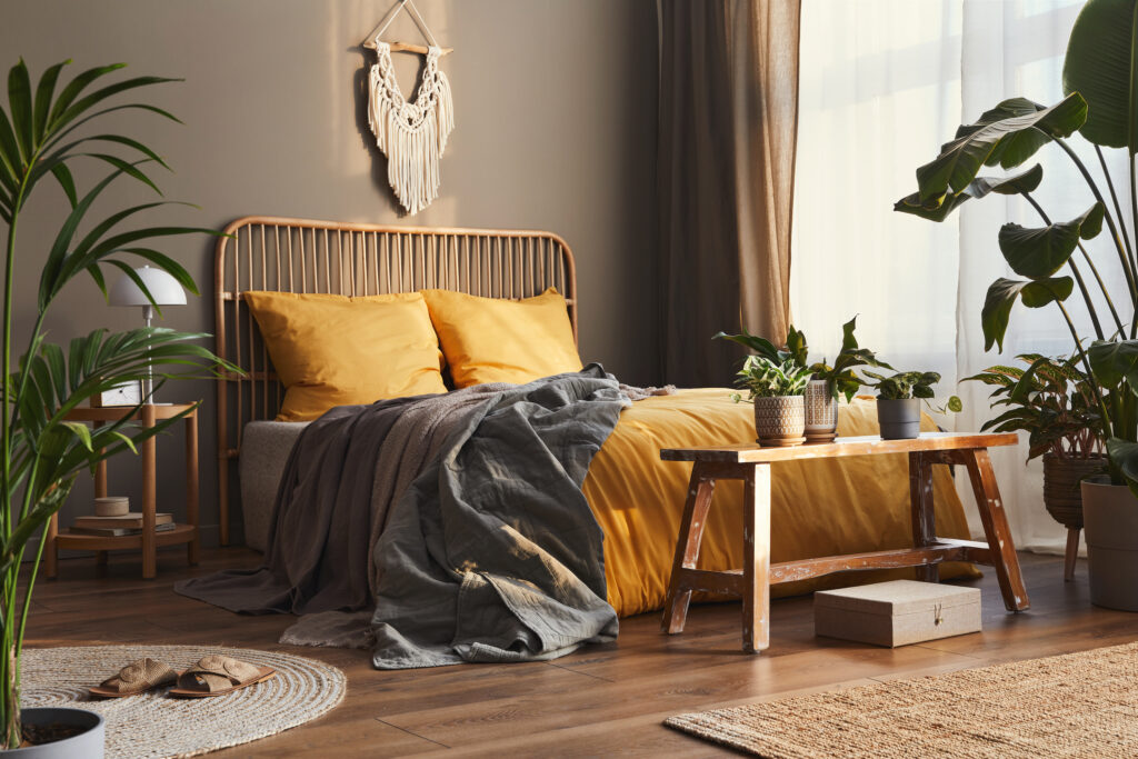 Picture of a bedroom with plants and orange sheets
