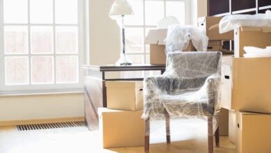 Picture of a room with moving boxes and a chair wrapped in bubble wrap